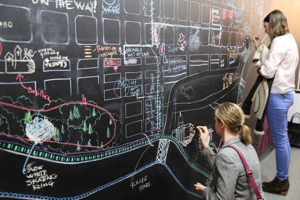 University Guiding Principles: photo of the Edmonton Wayfinding Project featuring people annotating the city on a chalk board