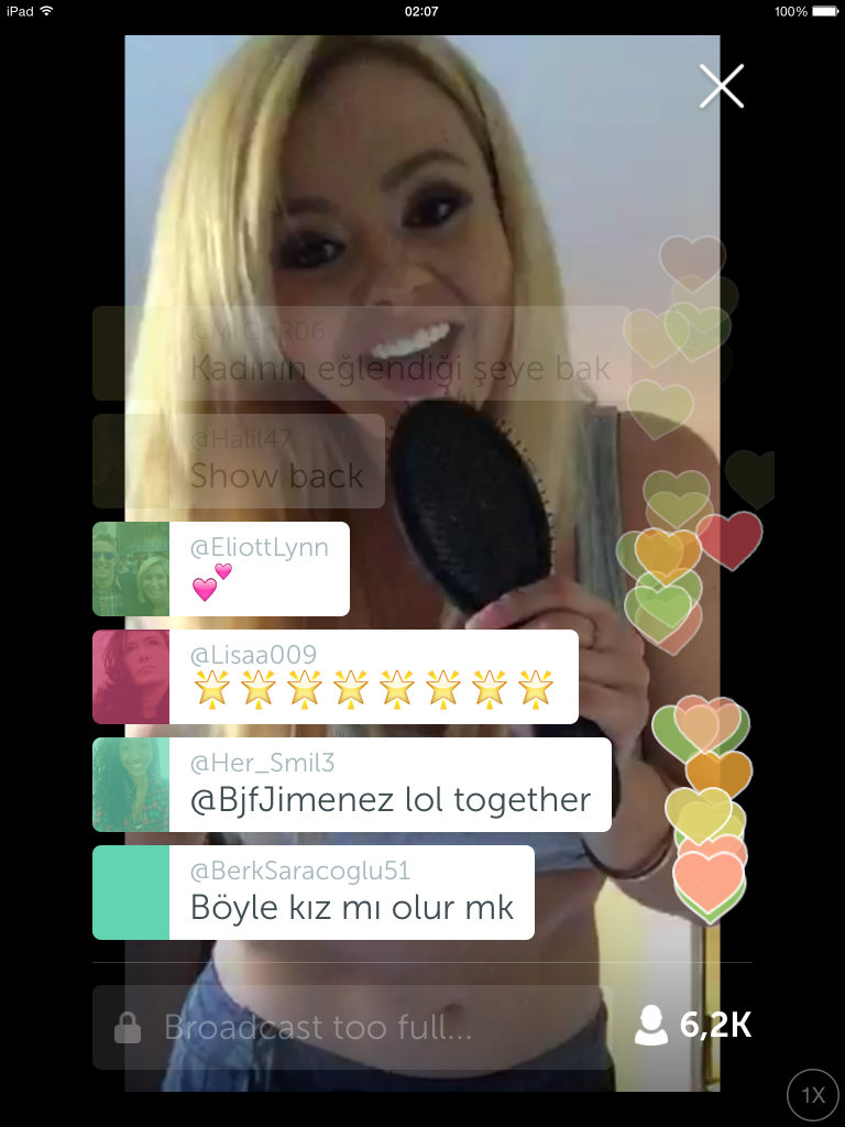 screen cap of professional Periscoper Bree Olson singing into a hairbrush and into her iPhone broadcasting on Periscope. Here image is surrounded by viewer comments and "hearts"