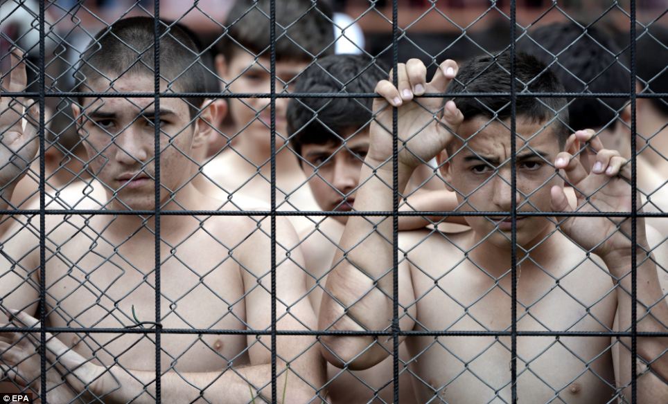 Group of young wrestlers in Turkey looking on from behind a fence