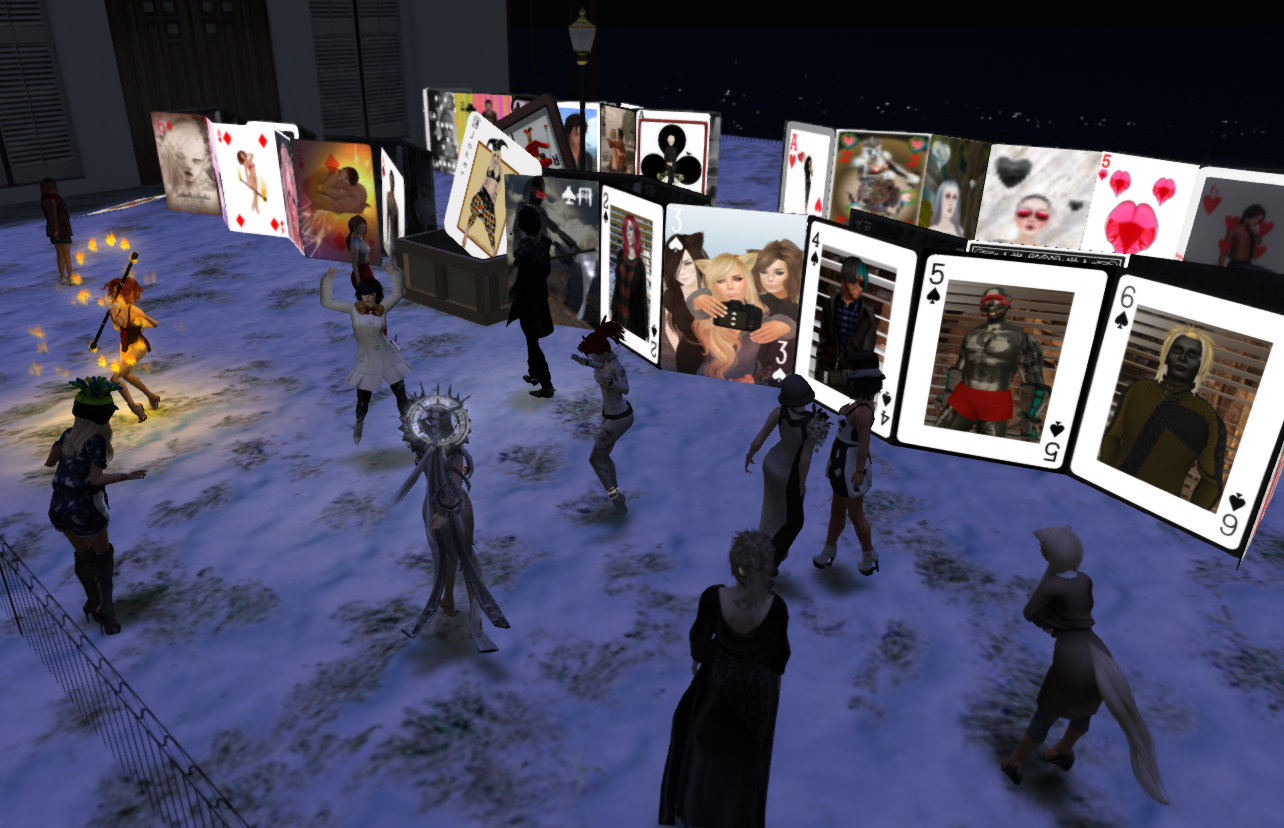 opening reception for avatar card deck. Avatars stand around and look at a giant deck of life-sized playing cards, each featuring a different selfie