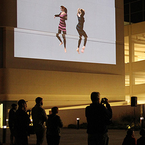 avatars dancing and projected on the side of a building