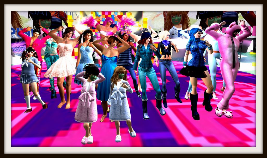 A large group of avatars, males in pink and females in blue, stand on the stage at Mikati Slade's Pico Pico LIfe at LEA19